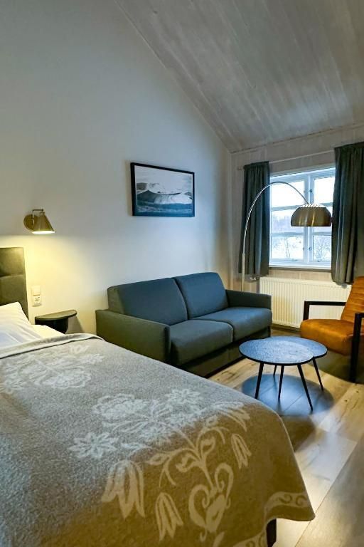 Een hotelkamer met een bed, een bank en een tafel