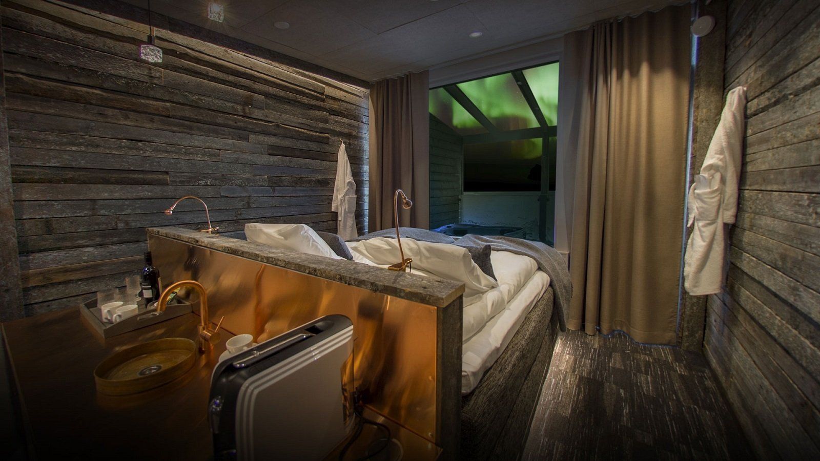 Een artist's impression van een hotelkamer met een bed en een koffer.
