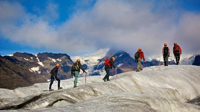 Een groep mensen loopt bovenop een met sneeuw bedekte berg.