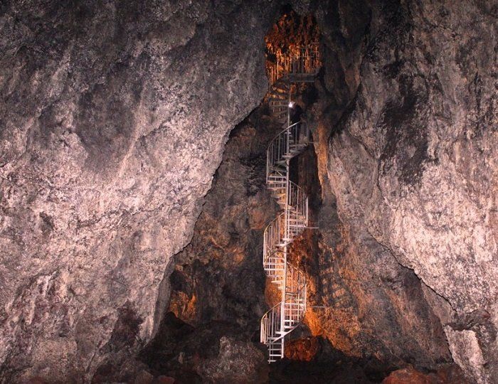Een trap in een grot die naar een waterval leidt