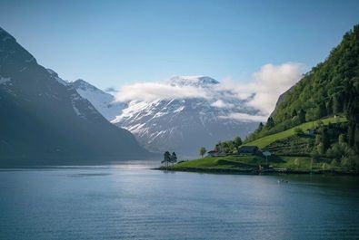 Een vrouw kijkt uit over de Geirangerfjord in Noorwegen