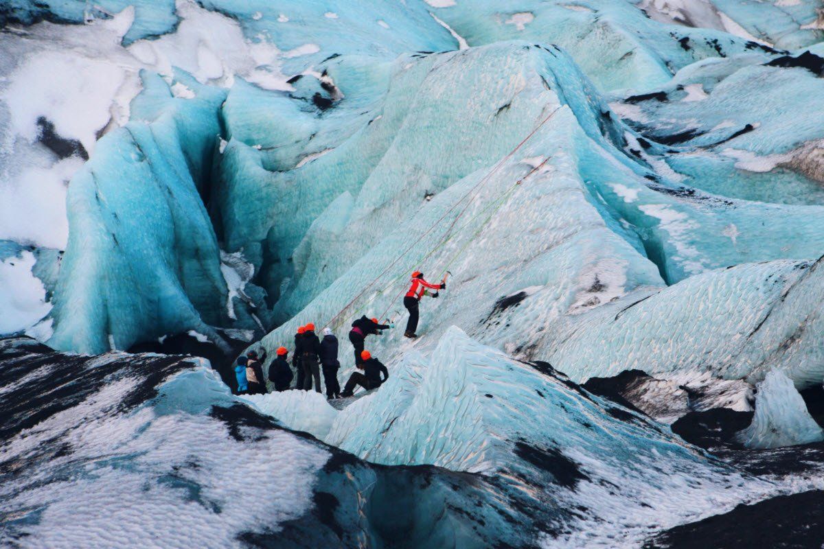 Een groep mensen staat bovenop een grote ijsberg.