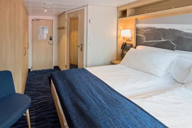 Een hotelkamer met een groot bed en een stoel.