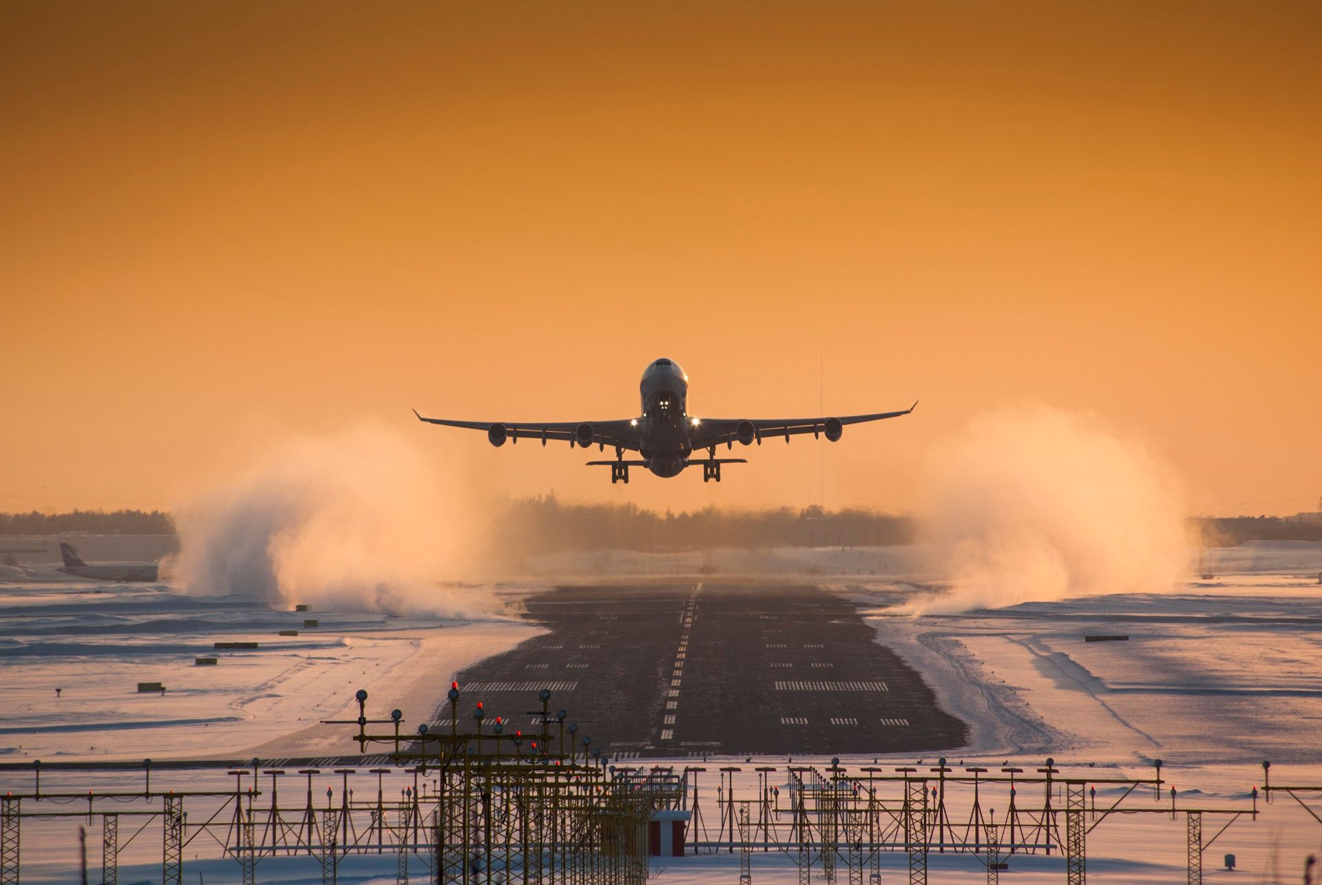 Een groot passagiersvliegtuig stijgt op van de landingsbaan van een luchthaven.