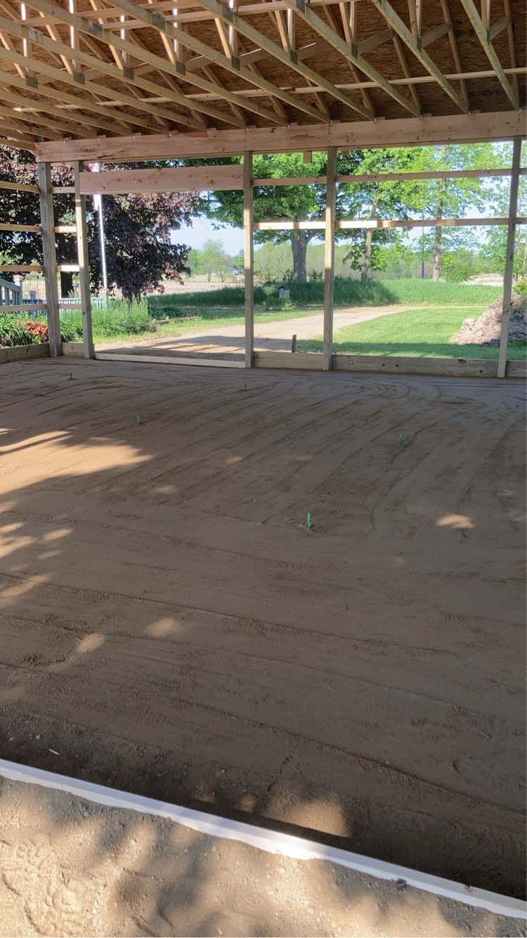 Construction site: Wood frame structure with dirt floor, open to a grassy outdoors.
