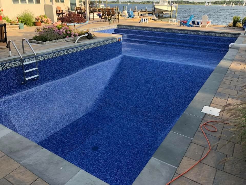 A large blue swimming pool with stairs leading to the water.