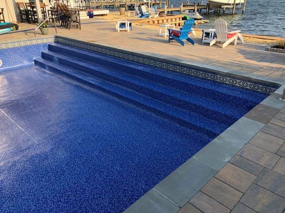 A blue swimming pool with stairs leading to the water.
