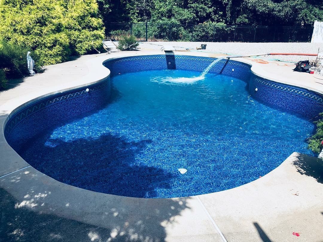 A large blue swimming pool with a fountain in the middle
