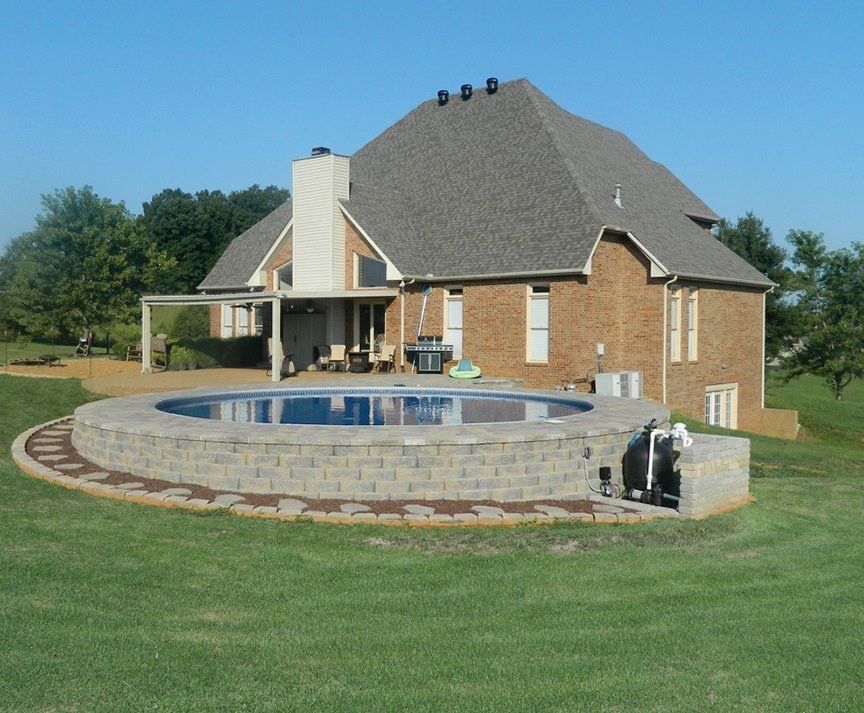 A large brick house with a large swimming pool in front of it