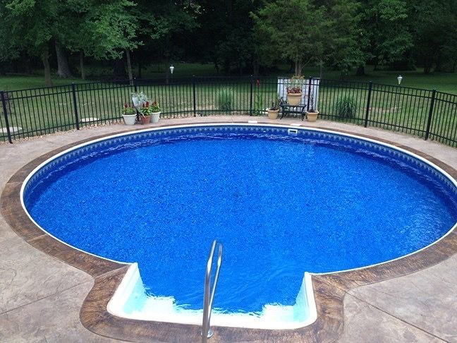 A large blue swimming pool with a fence around it
