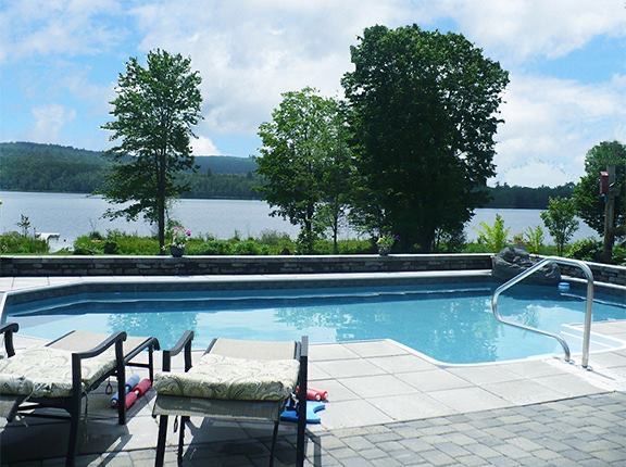 A large swimming pool with a view of a lake