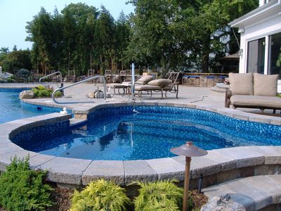 A large swimming pool with a hot tub in the middle