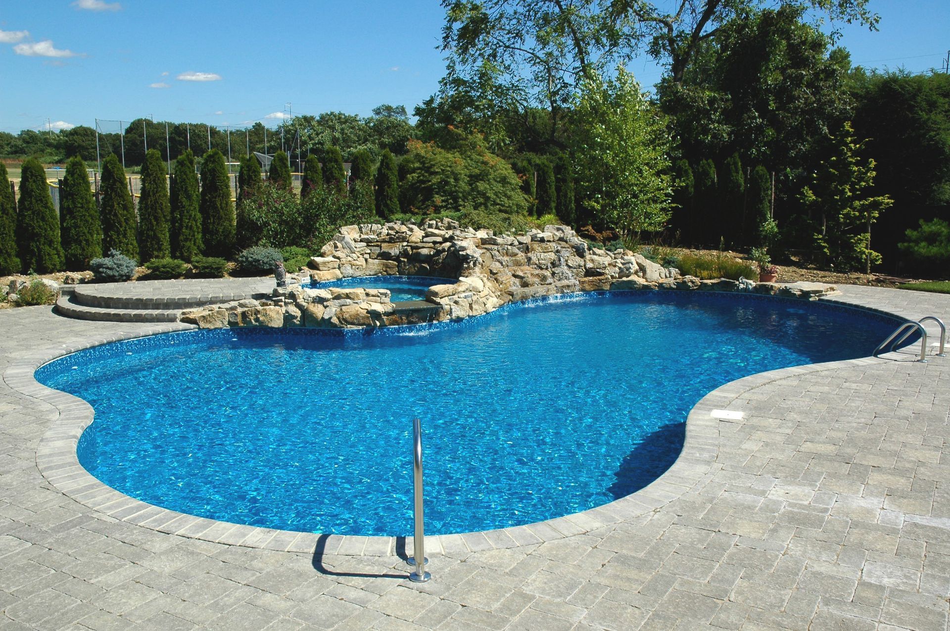A large swimming pool with a waterfall in the background