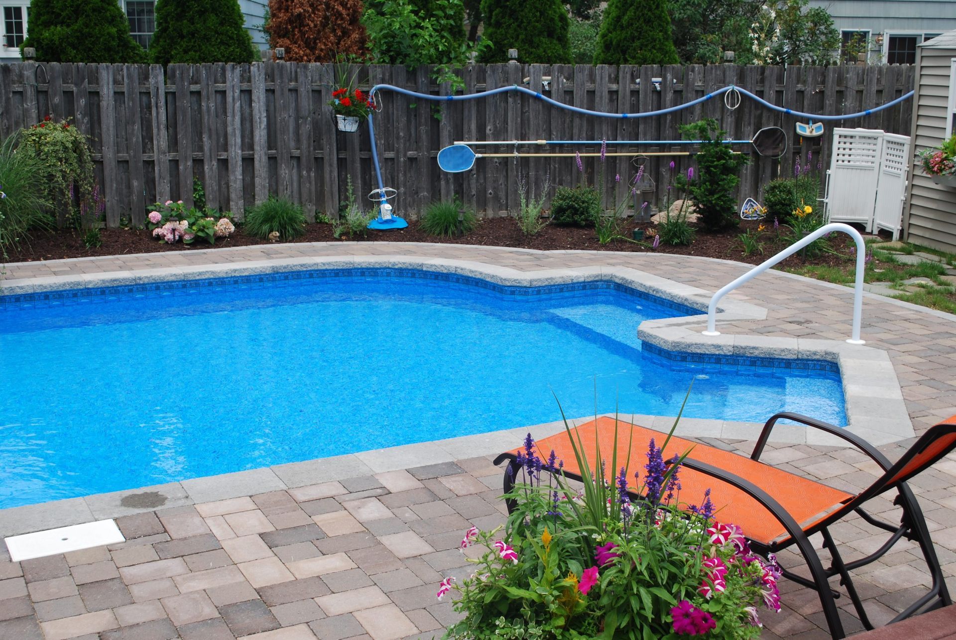 A large swimming pool with a wooden fence surrounding it