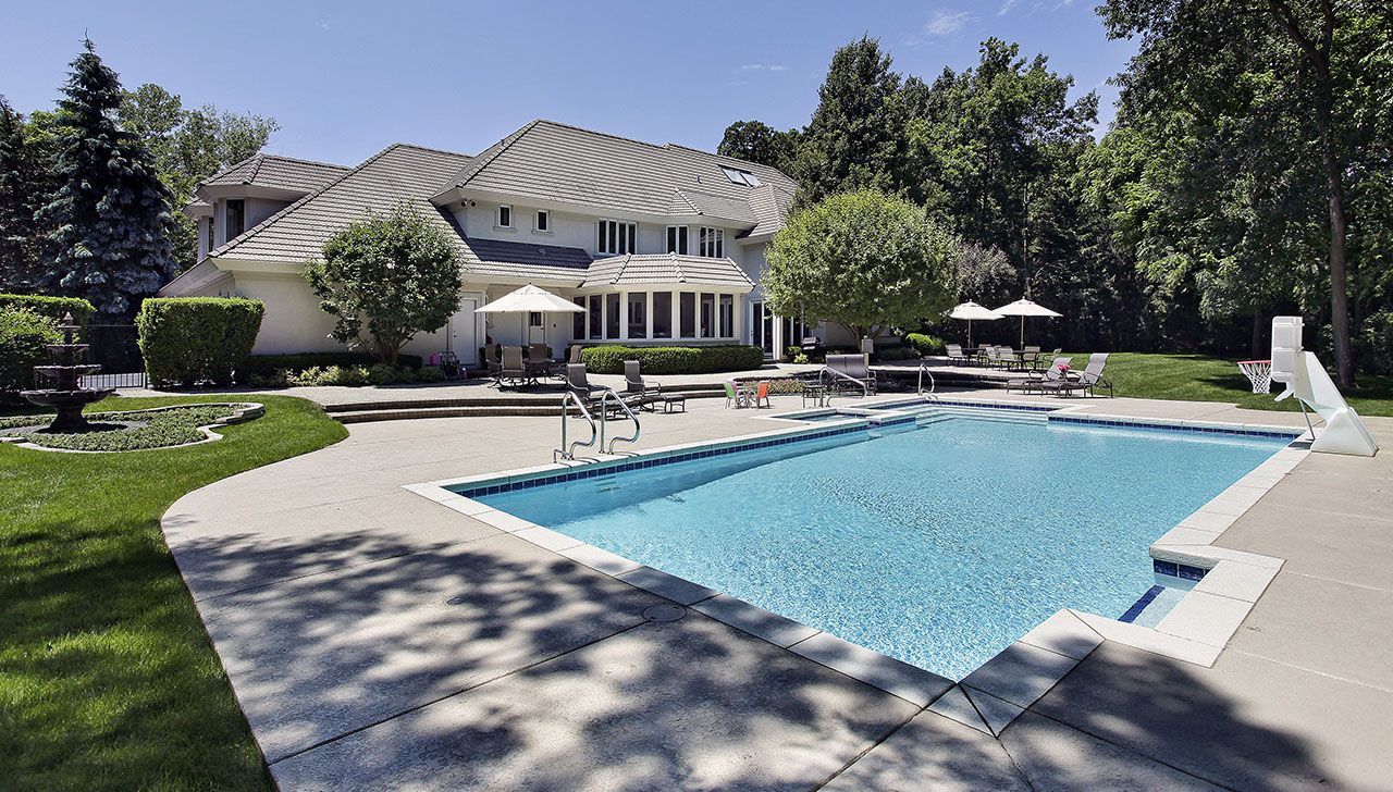A large house with a large swimming pool in front of it