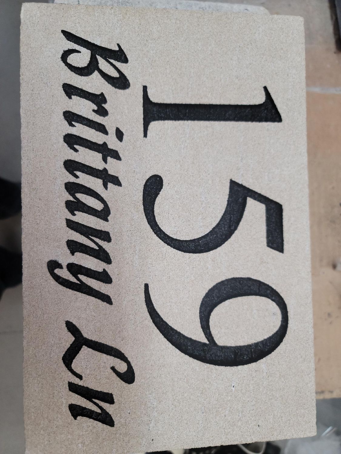 Sand-colored doormat with black text: 