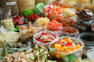 A person holding a baby up in the air indoors near a window, baby smiling.