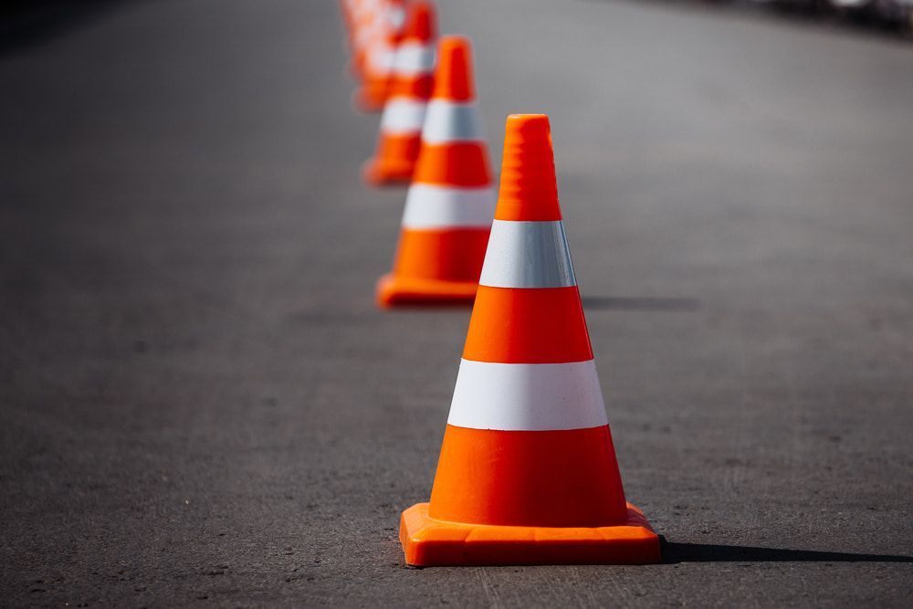 A Row Of Orange And White Traffic Cones On The Side Of A Road — Territory Bitumen Services In Tivendale, NT