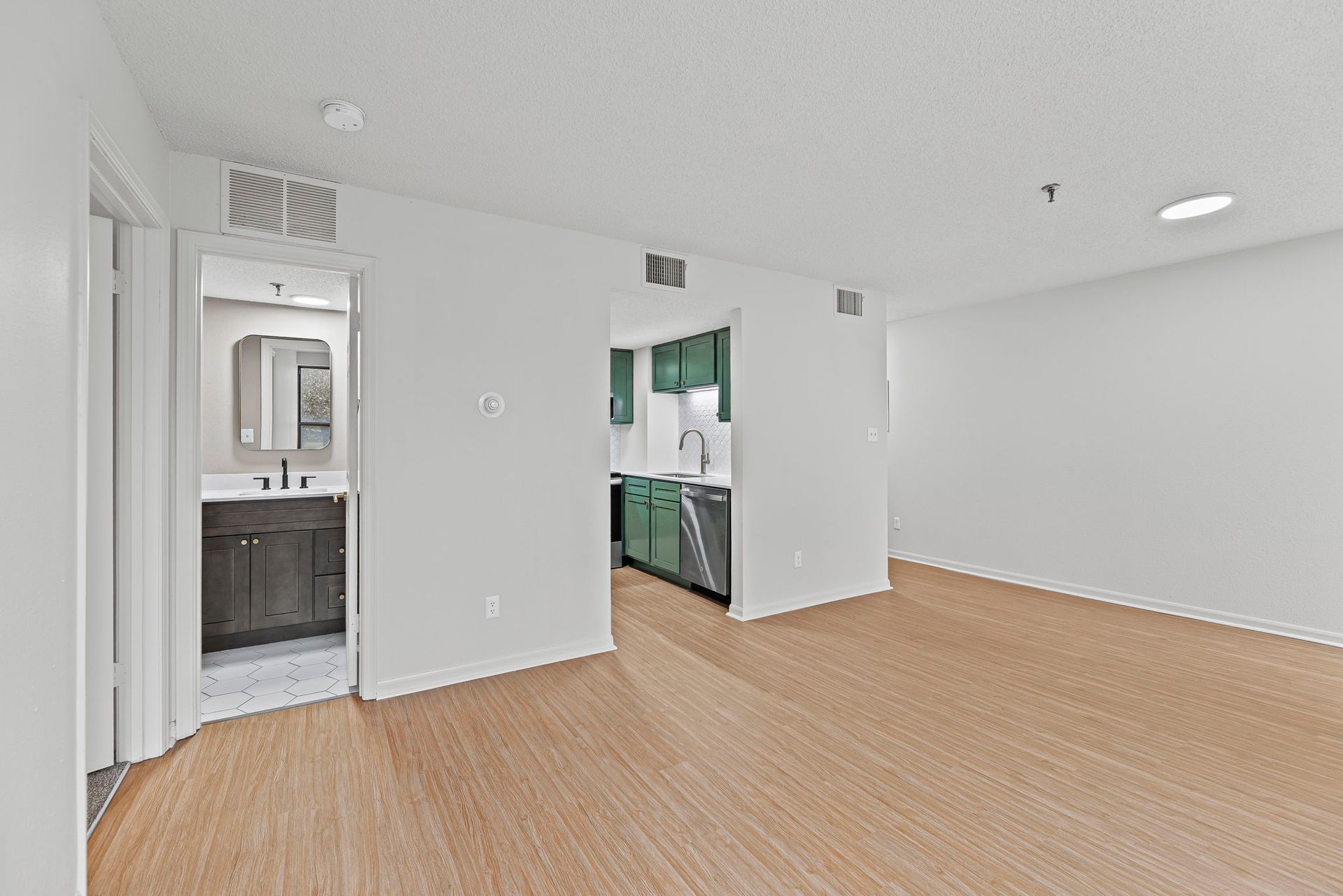 Renovated apartment kitchen with updated cabinetry and lighting