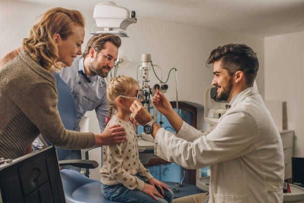 Eye exam at Calvert Ophthalmology Center in Nashville, TN, with an optometrist testing a child's vision as parents observe