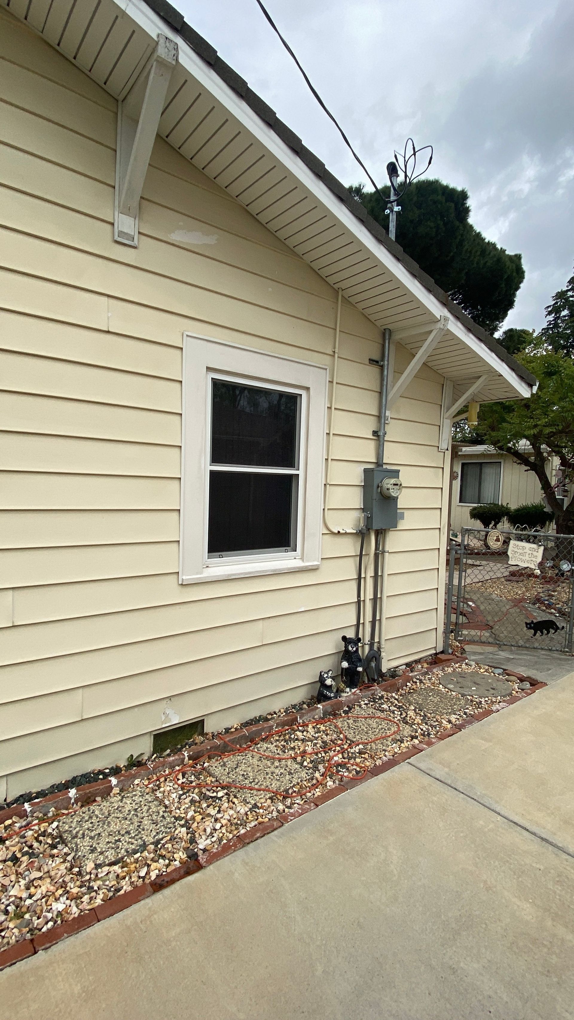The side of a house with a window and a roof.