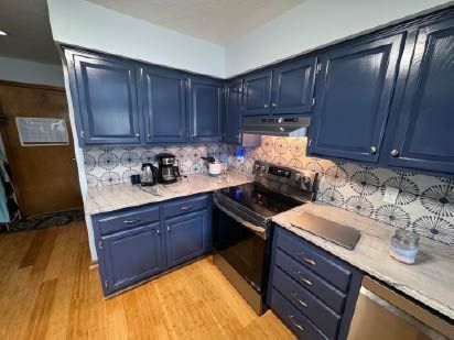A kitchen with oak cabinets that were painted indigo batik, with a modern backsplash