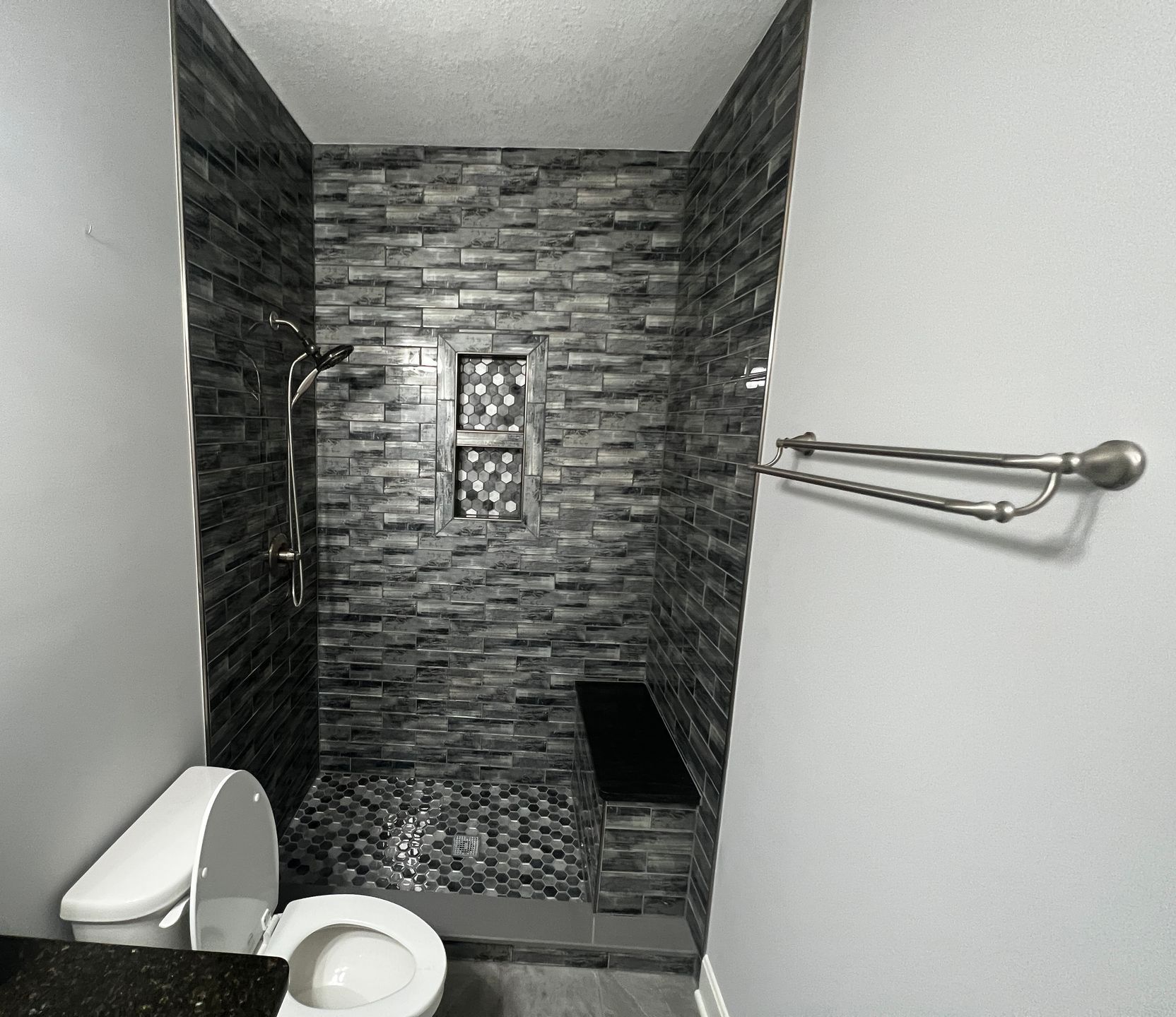 A black and white photo of a bathroom with a toilet and shower