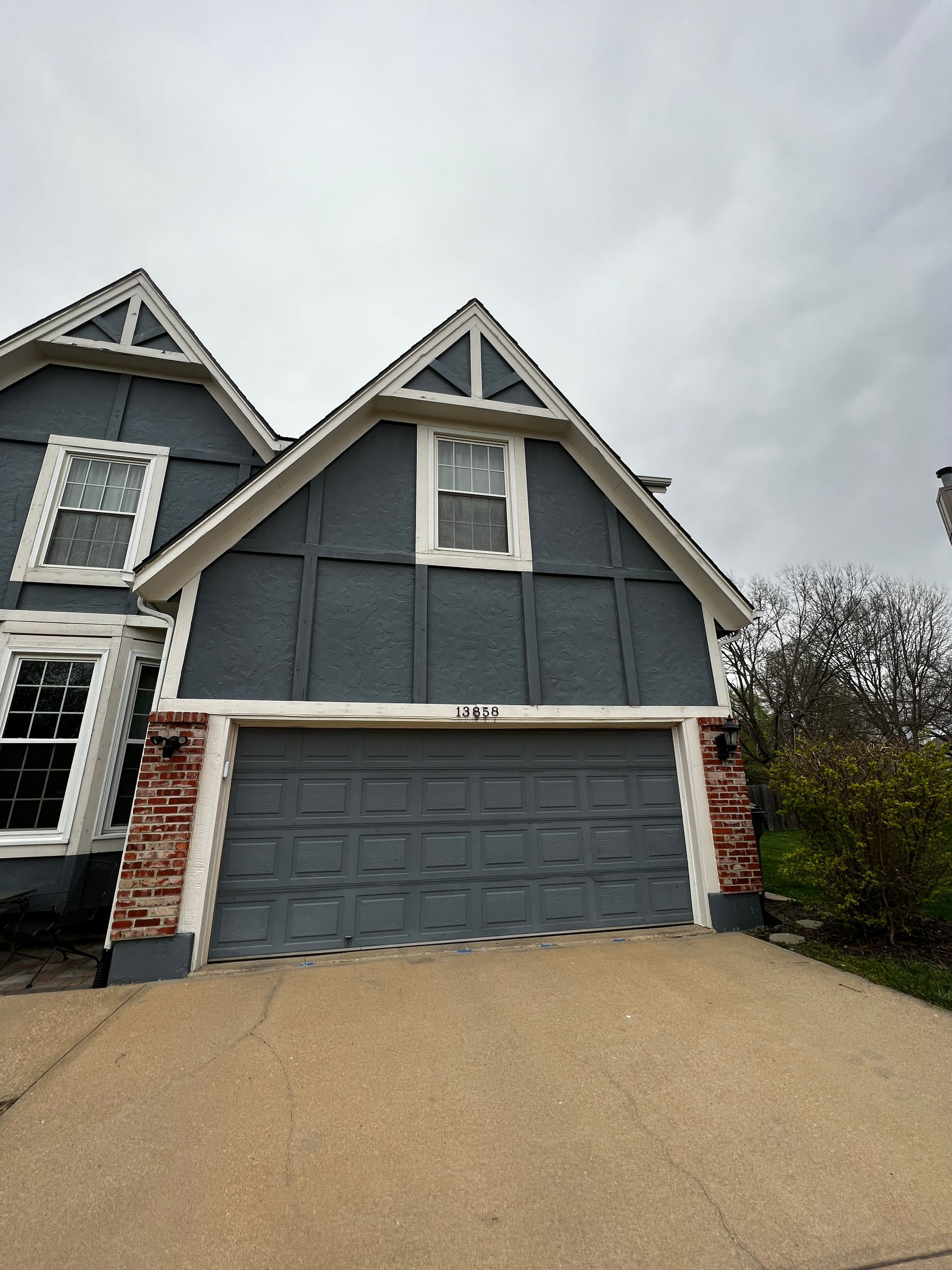 A newly painted exterior blue house with a white trim and a garage door