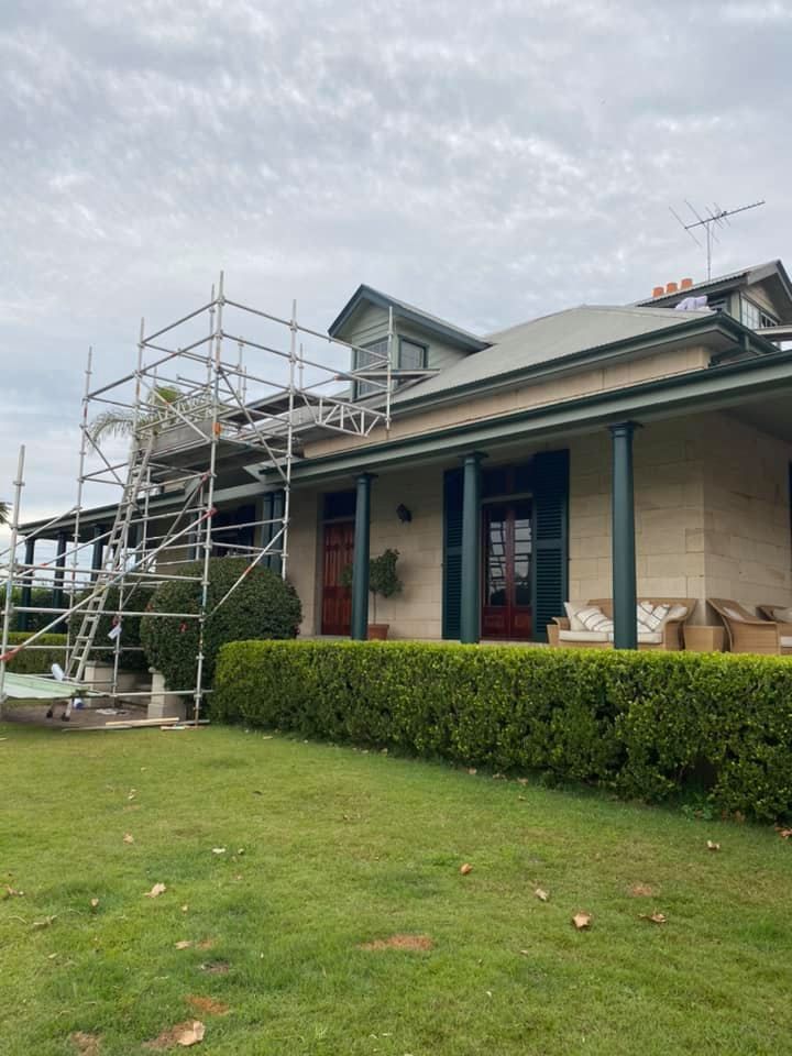 Scaffolding Set Up Next to a House With a Green Roof — S D Maintenance In Point Clare, NSW