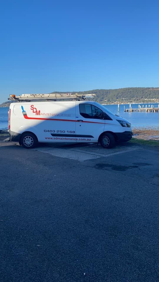 White Service Van Parked Near a Body of Water Under a Clear, Blue Sky โ S D Maintenance In Point Clare, NSW