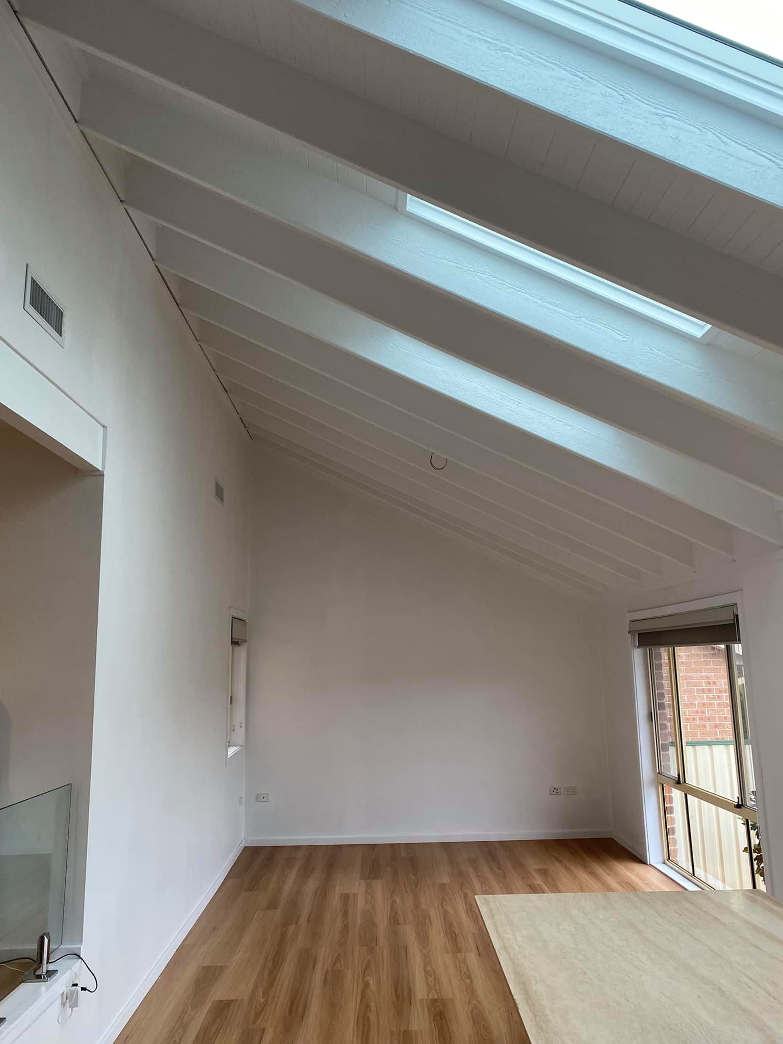 Interior View of a Room With a Sloped White Ceiling and Wooden Floors — S D Maintenance In Kincumber, NSW