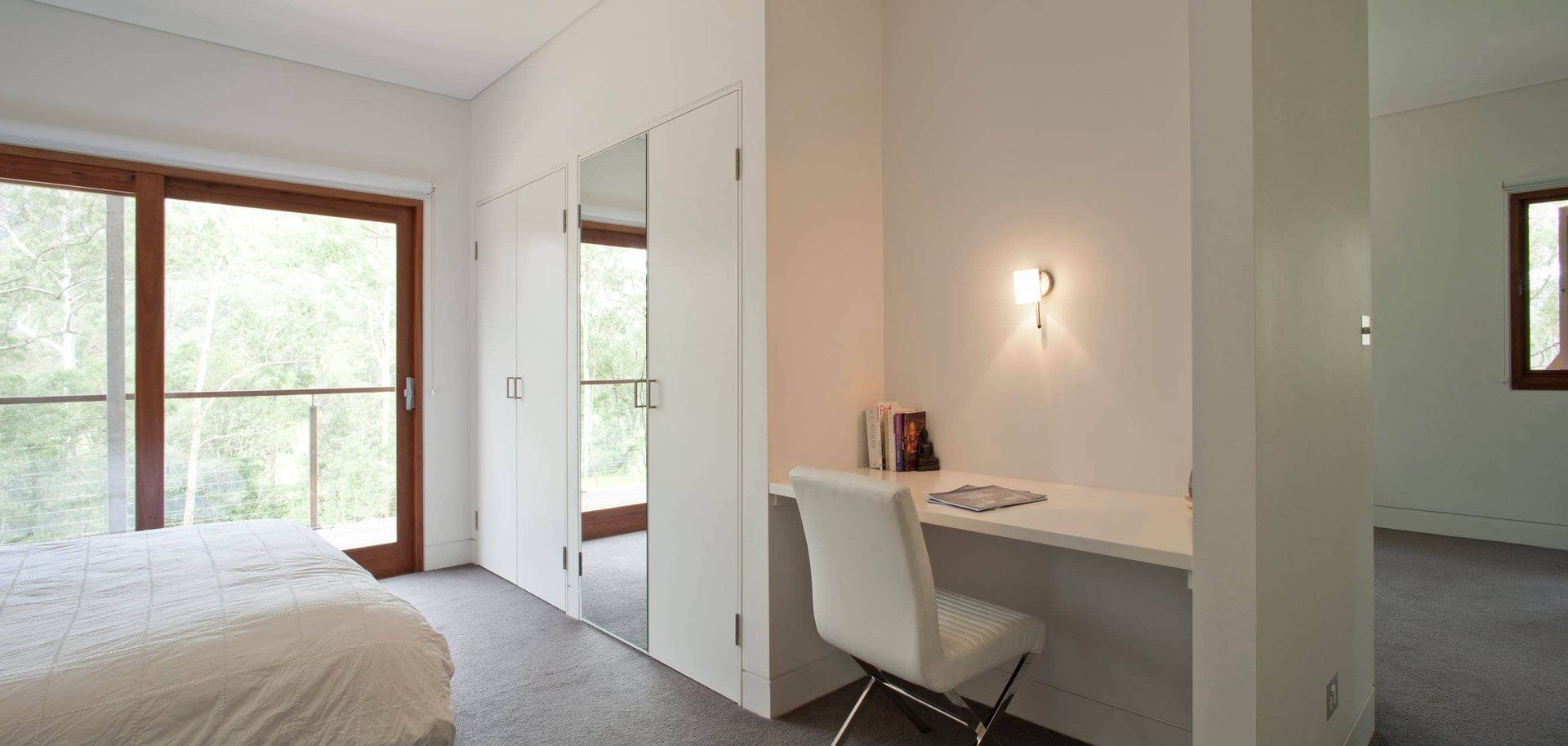 A Modern Bedroom With a Desk and a Large Window — S D Maintenance In The Entrance, NSW