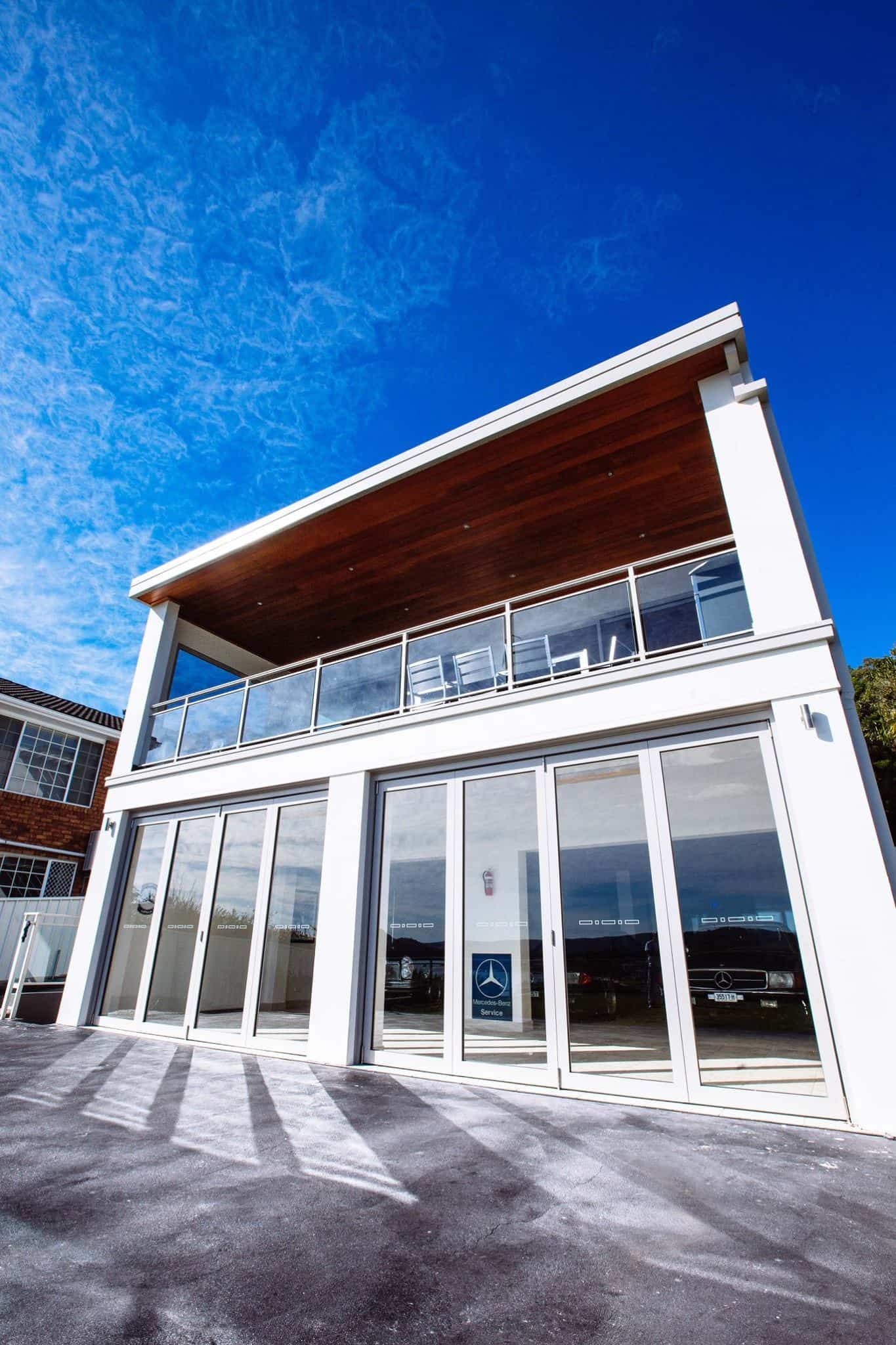 Modern White Building With Glass Doors and Balcony Against a Bright Blue Sky — S D Maintenance In The Entrance, NSW
