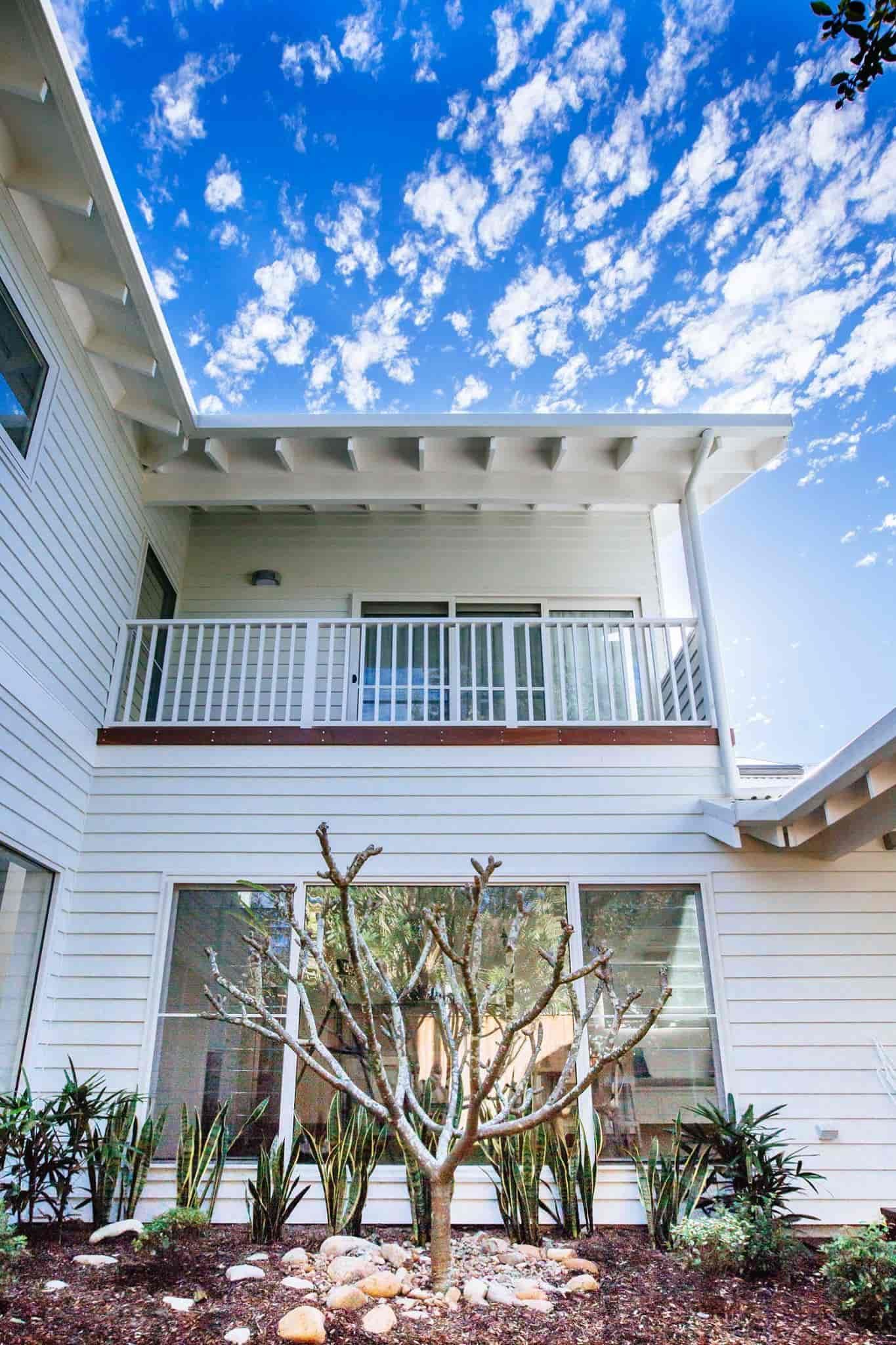 White House Exterior With a Balcony, Blue Sky With Clouds, and a Small Tree in Front — S D Maintenance In Point Clare, NSW