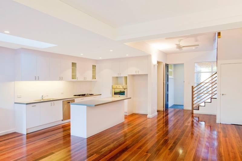 Bright, Open-concept Kitchen With White Cabinets and Wooden Floors — S D Maintenance In The Entrance, NSW