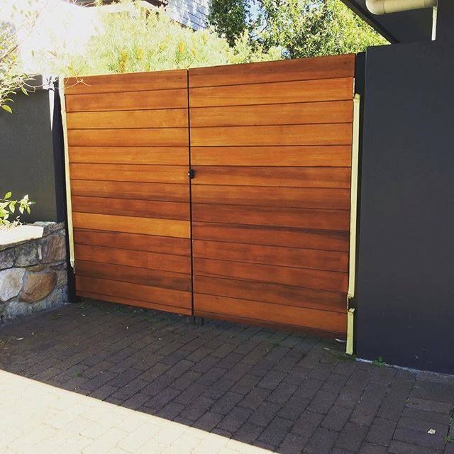 Wooden Gate Closed Against a Black Wall, Brick Driveway — S D Maintenance In Erina, NSW