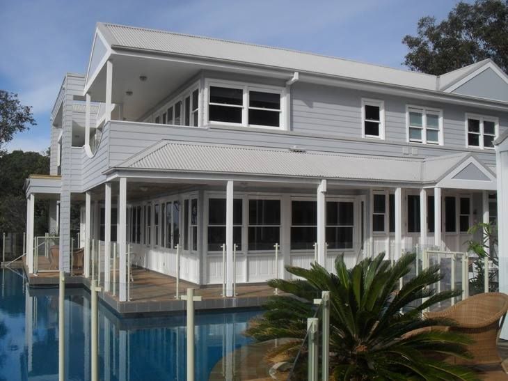 Two-Story Gray House With a Pool, White Trim, and a Veranda — S D Maintenance In The Entrance, NSW