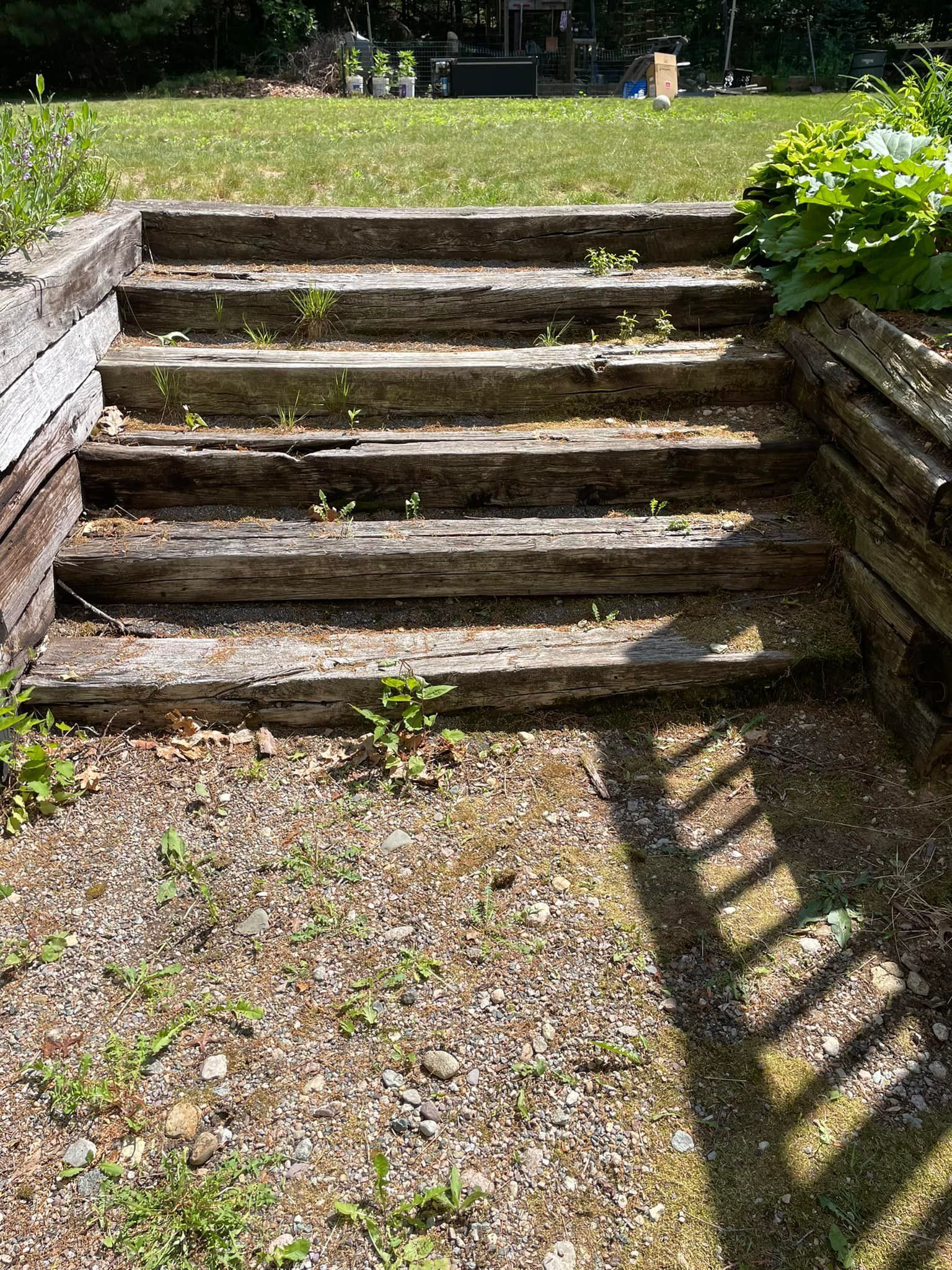 A set of wooden stairs leading up to a grassy field.