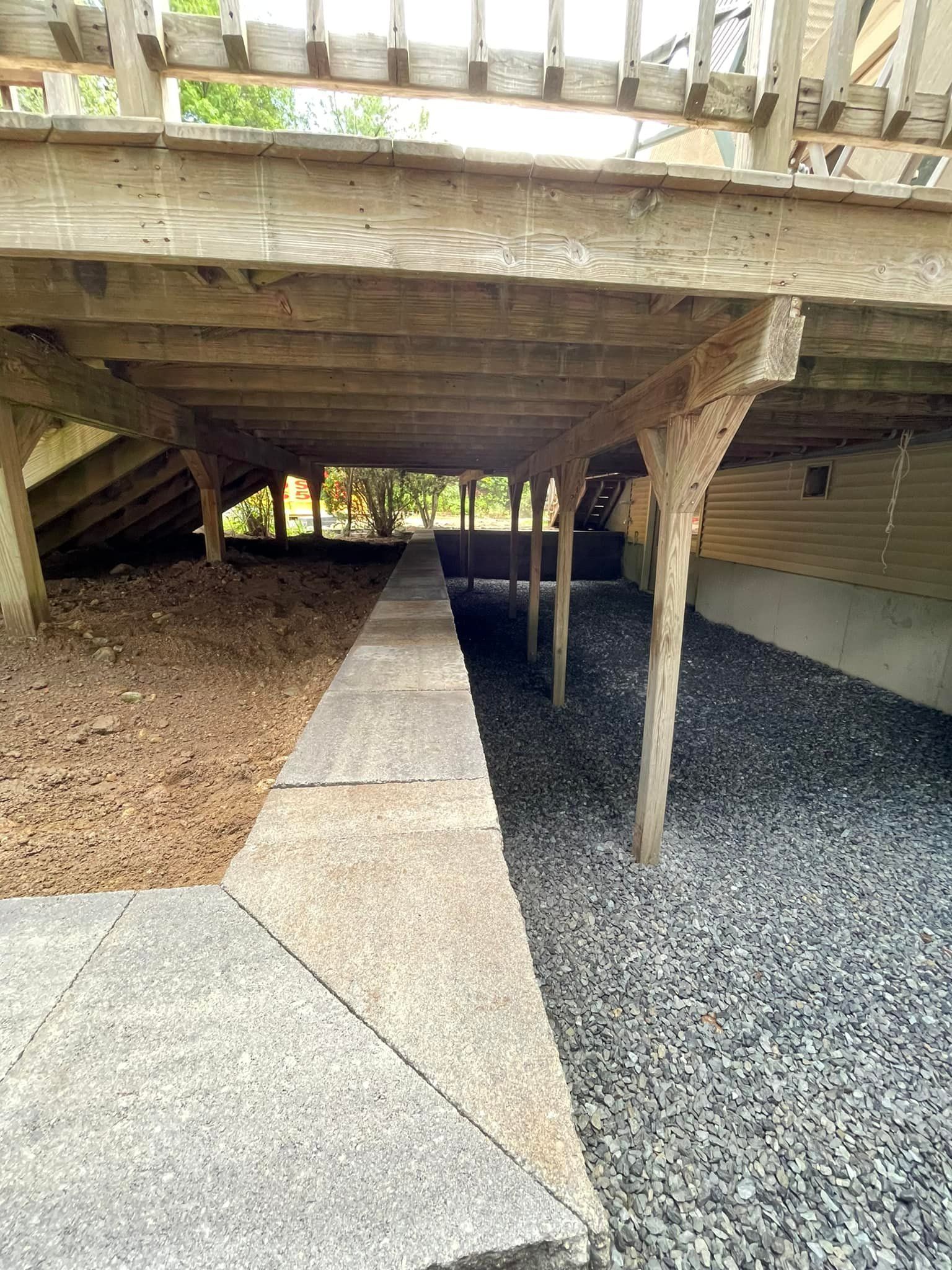 A wooden deck with a walkway underneath it.