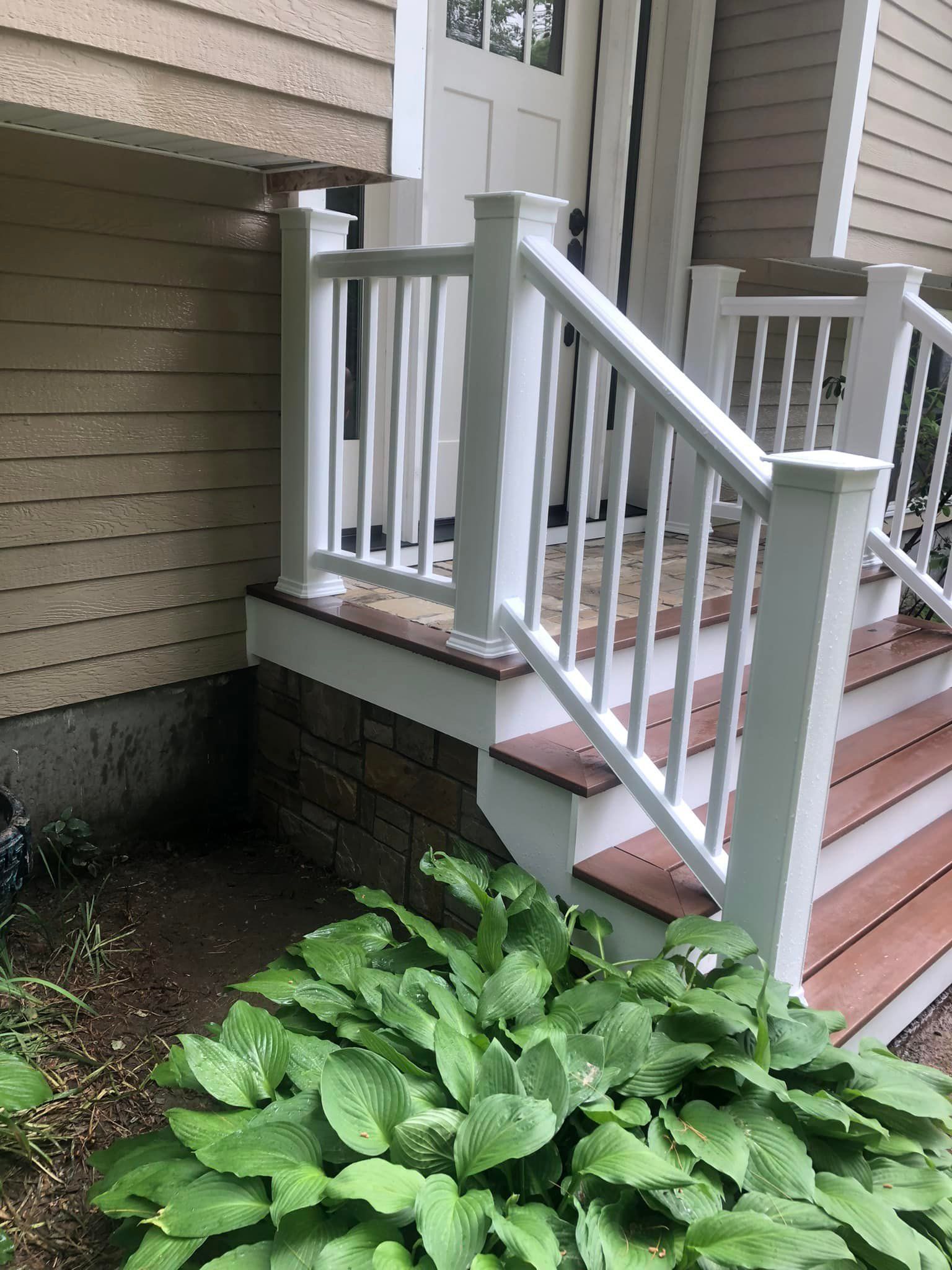There is a white railing on the stairs of a house.