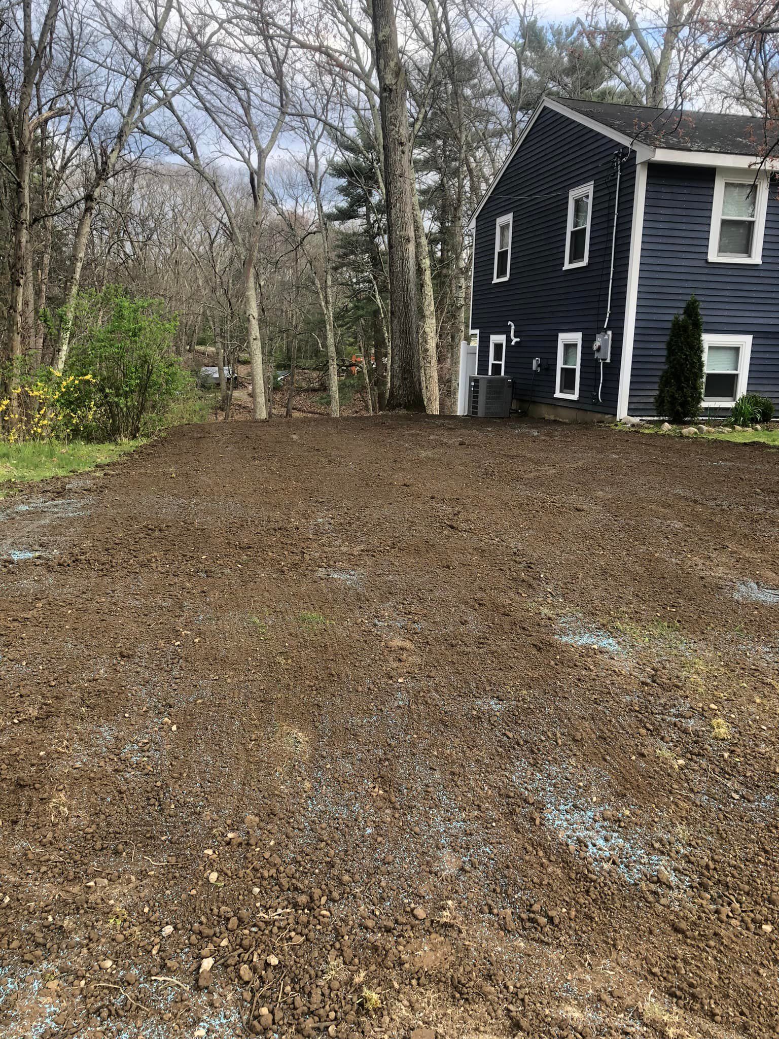 A blue house with a lot of dirt in front of it.