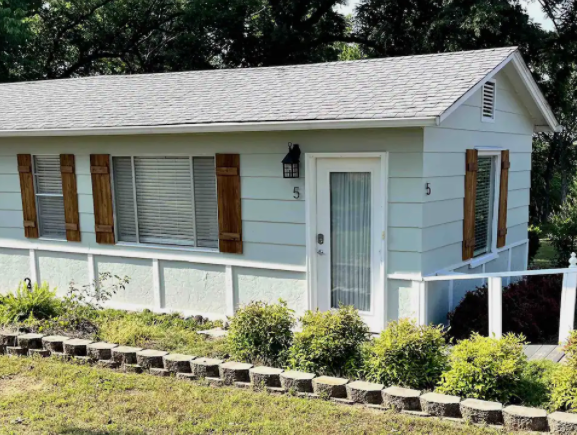 A small white house with brown shutters on the windows
