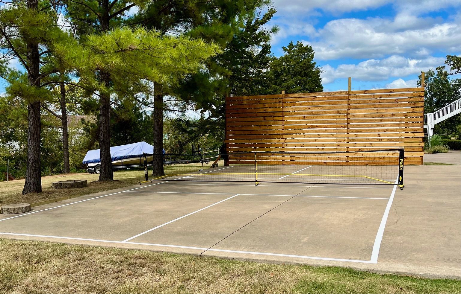 A tennis court with a wooden wall in the background.