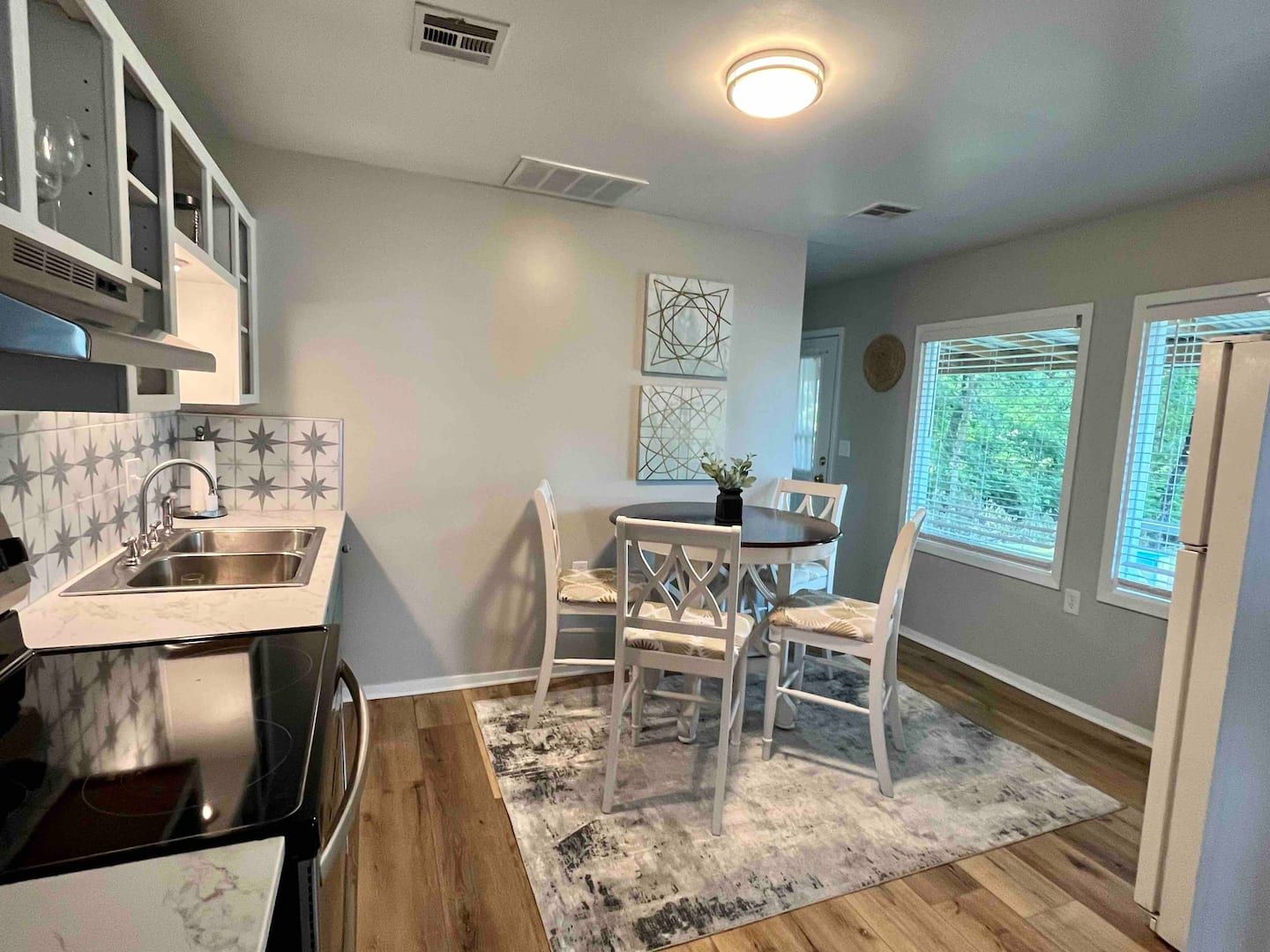 A kitchen with a table and chairs in it and a rug on the floor.