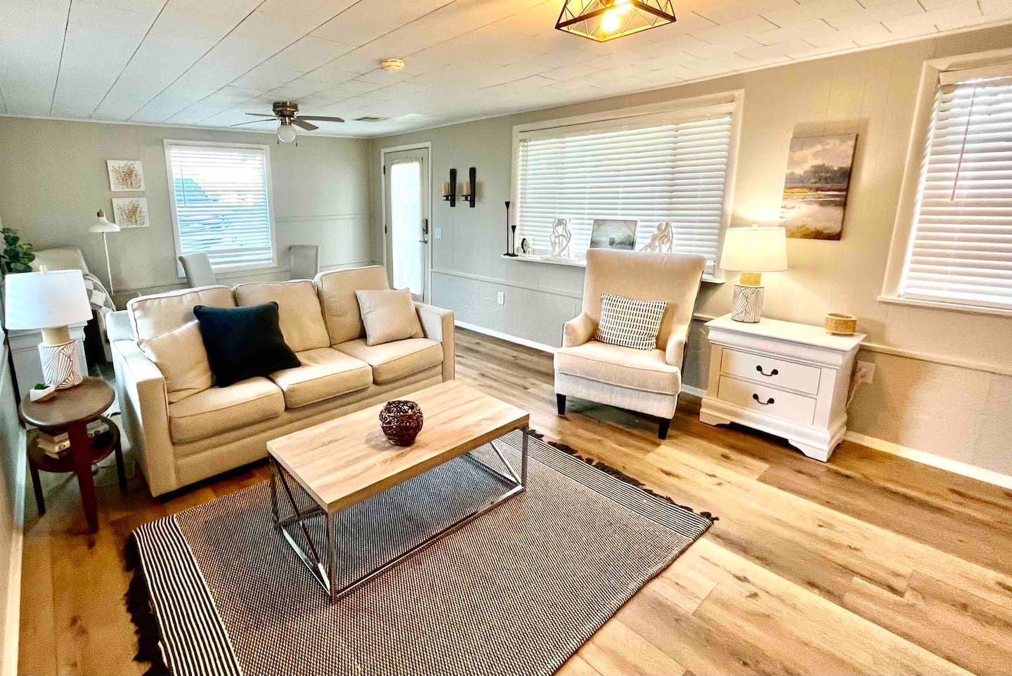 A living room with a couch , chair , coffee table and rug.