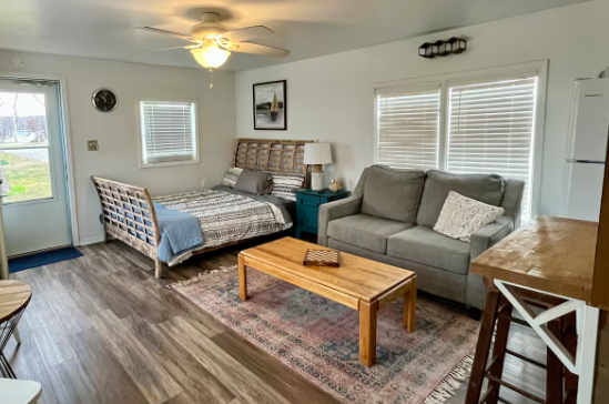 A living room with a couch , table , and bed.
