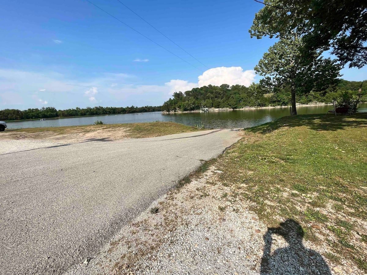 A road leading to a lake with trees on the side of it