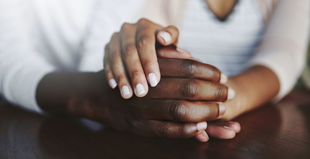 A woman is holding a man 's hand while sitting at a table.