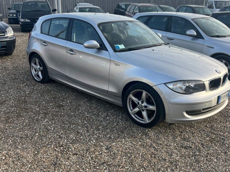 una persona tiene in mano le chiavi davanti a un'auto.