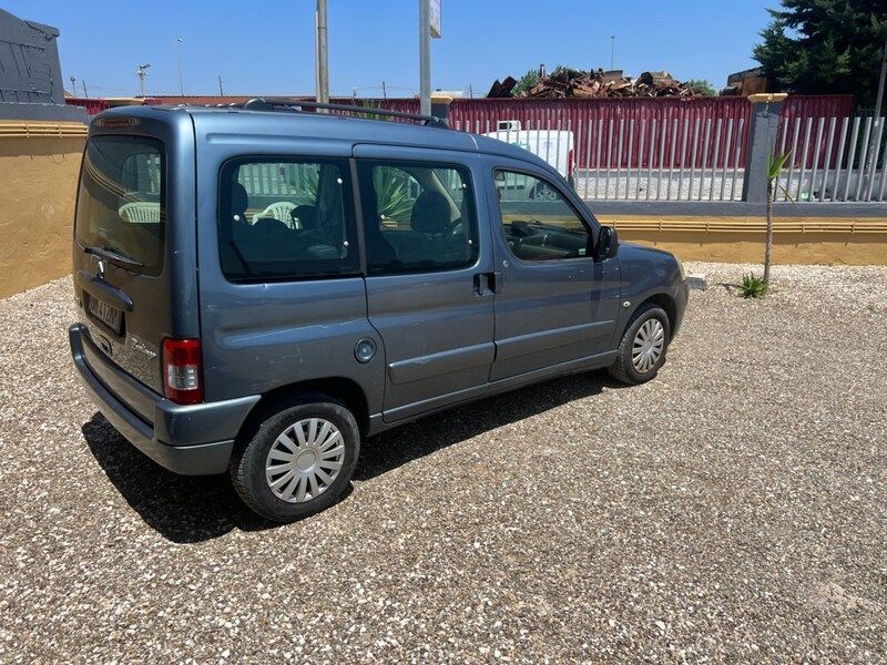 un uomo in giacca e cravatta sta firmando un documento accanto alla chiave della macchina.